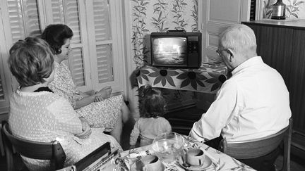 Une famille&nbsp;devant sa télévision, le 21 juillet 1969, pour regarder les premiers pas de l'homme sur la Lune. (AFP)