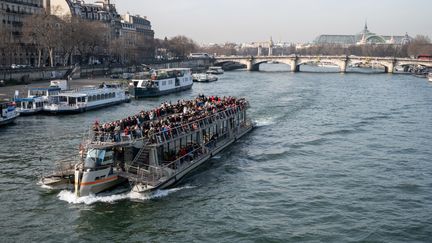 Des touristes parcourent la Seine, à Paris, le 21 février 2023. (RICCARDO MILANI / HANS LUCAS / AFP)