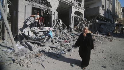 Des habitants devant les décombres d'immeubles bombardés par l'armée israélienne, dans la bande de Gaza, le 12 octobre 2023. (AHMED TAWFEQ APA IMAGES / SIPA)