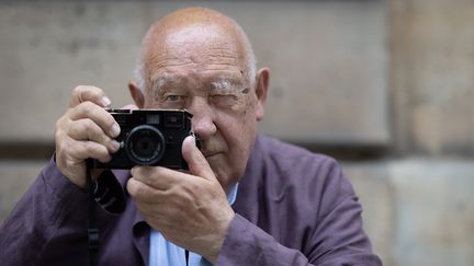 Le photographe et réalisateur français Raymond Depardon avec son appareil photo, le 24 juin 2024. (JOEL SAGET / AFP)