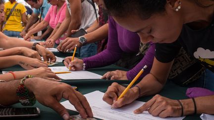 Des supporters de l'opposition vénézuélienne signent une pétition pour demander un référendum contre le président Nicolas Maduro, le 27 avril 2016.&nbsp; (CITIZENSIDE/ANDREA HERNANDEZ / CITIZENSIDE / AFP)