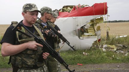 &nbsp; (Des militants prorusses protègent les débris du Boeing 777 qui s'est écrasé jeudi dans l'est de l'Ukraine. © MaxPPP / Anastasia Vlasova)