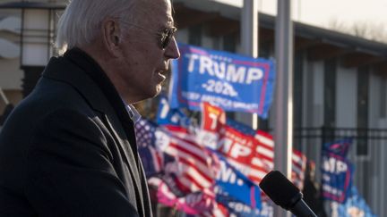 Des supporteurs de Donald Trump agitent des drapeaux au nom du président lors d'un meeting de son rival démocrate, Joe Biden, à Saint-Paul, dans le Minnesota, le 30 octobre 2020.&nbsp; (JIM WATSON / AFP)