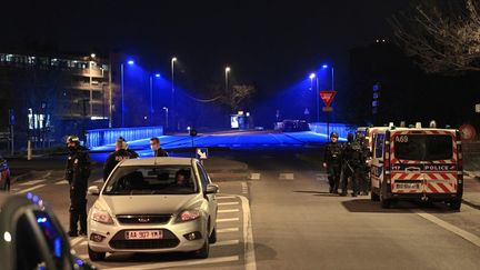 Des policiers patrouillent dans une rue suite à des émeutes et après que plusieurs voitures aient été incendiées dans le quartier de Parilly à Bron, près de la ville de Lyon, le 6 mars 2021. (OLIVIER CHASSIGNOLE / AFP)