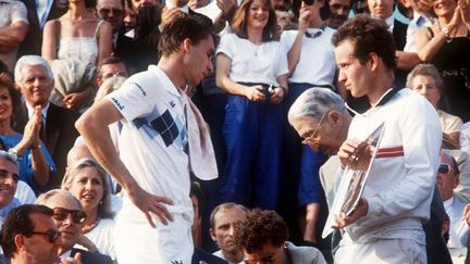 Ivan Lendl attend de soulever la Coupe des Mousquetaires à côté de John McEnroe (1984) (DOMINIQUE FAGET / AFP)