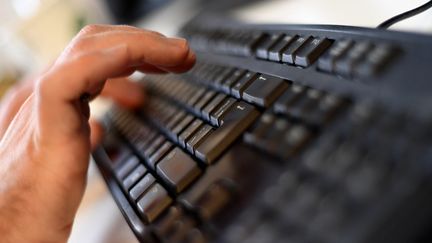 Une main au dessus d'un clavier d'ordinateur. (KIRILL KUDRYAVTSEV / AFP)