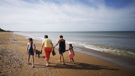 Une famille se balade sur la plage de Cabourg (Calvados), le 13 octobre 2018. (CHARLY TRIBALLEAU / AFP)