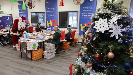 Des employés de La Poste déguisés en elfes et en père Noël ouvrent des lettres envoyées par des enfants au bureau de poste de Libourne (Gironde), le 10 décembre 2020. (THIBAUD MORITZ / AFP)