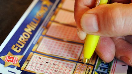 Un homme remplit une grille d'Euro Millions, le 7 ao&ucirc;t 2012 &agrave; Lille.&nbsp; (PHILIPPE HUGUEN / AFP)