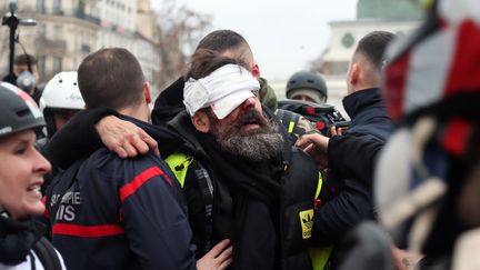 Jérôme Rodrigues est évacué après avoir été blessé à l'œil par un projectile, place de la Bastille, le 26 janvier 2019. (ZAKARIA ABDELKAFI / AFP)