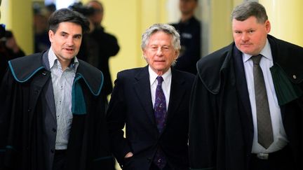 Roman Polanski, accompagné par ses deux avocats de l'époque, à la Cour régional de Cracovie qui devait, en 2015, trancher sur l'extradition du réalisateur franco-polonais vers les Etats-Unis du fait des poursuites pour agression sexuelle. La Cour a finalement bloqué l'extradition. 
 (JANEK SKARZYNSKI / AFP)