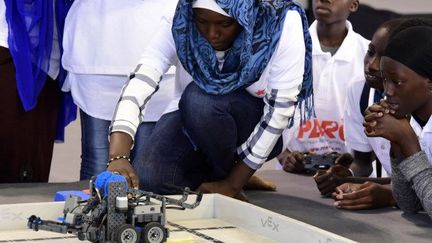 Une jeune femme prépare son robot pour la finale de la compétition de robots à Dakar le 20 mai 2017 (SEYLLOU / AFP)