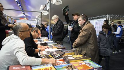 Des dessinateurs dédicacent leur ouvrages lors du festival de BD d'Angoulême (Charente), le 29 janvier 2015. (PIERRE DUFFOUR / AFP)