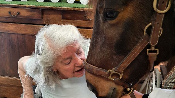 Une résidente de l'Ehpad embrasse Sioux, la ponette qui vient rendre visite à l'Ehpad d'Angoulême. (ALAIN GASTAL / RADIO FRANCE)