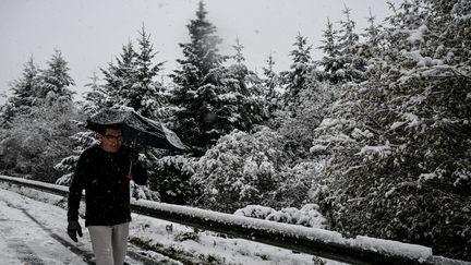 Un conducteur qui a dû quitter sa voiture, bloquée par la neige, dans le Calvados, le 21 novembre 2024. (MARTIN ROCHE  / MAXPPP)