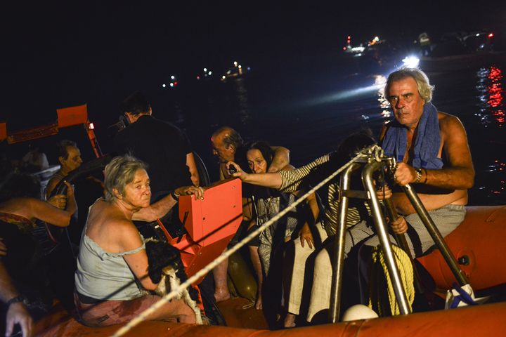 Des habitants du village de Mati (Grèce) évacués le 23 juillet 2018 après les incendies. (ANGELOS TZORTZINIS / AFP)