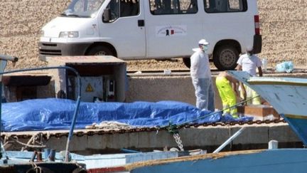 Des volontaires et des médecins s'activent sur le bateau où 25 réfugiés morts ont été trouvés. (AFP-Alessia Capasso)