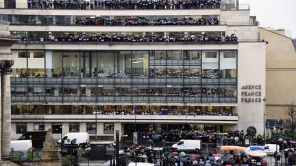 Journalists of international press agency Agence France-Presse (AFP) hold signs reading "Je suis Charlie" (I am Charlie) at their headquarters in Paris as they observe a minute of silence on January 8, 2015 (FRANCOIS XAVIER MARIT / AFP)