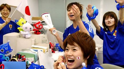 Des employés de l'entreprise de jouets Takara, à Tokyo, fêtent la victoire de leur équipe nationale de football.
	  (AFP PHOTO/Yoshikazu TSUNO)