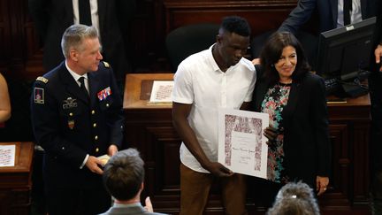 Mamoudou Gassama reçoit la médaille Grand Vermeil des mains de la maire de Paris, Anne Hidalgo, le 4 juin 2018. (FRANCOIS GUILLOT / AFP)