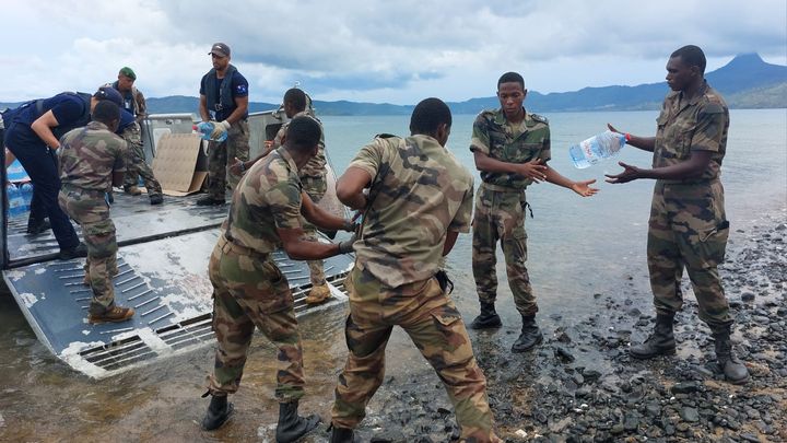 Des militaires débarquent des bidons d'eau, à destination de la population mahoraise, le 26 décembre 2024. (AGATHE MAHUET / RADIO FRANCE)