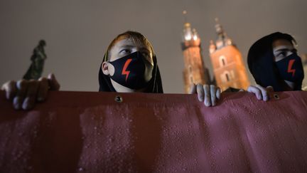 Des manifestants portent des masques floqués d'un éclair rouge, symbole de la lutte pour le droit à l'avortement, à Cracovie (Pologne), le 30 octobre 2020. (ARTUR WIDAK / NURPHOTO)