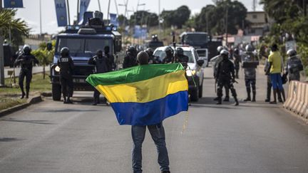 Un manifestant anti-Bongo se tient à Libreville (Gabon) devant les forces de l'ordre, le 31 août 2016. (MARCO LONGARI / AFP)