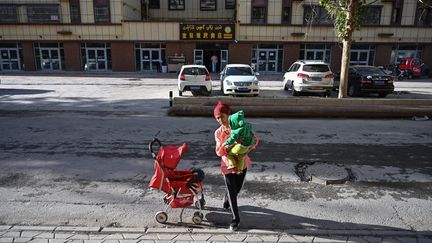 Une habitante d'un quartier ouïghour, à Aksu, dans la région chinoise du Xinjiang, le 11 septembre 2019. (HECTOR RETAMAL / AFP)