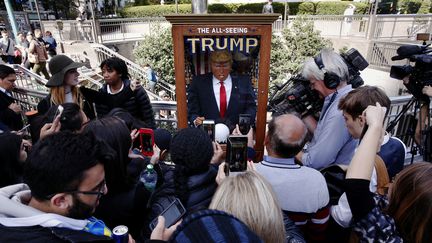 Des piétons photographient l'automate Donald Trump à New York, le 12 octobre 2016. (LUCAS JACKSON / REUTERS)