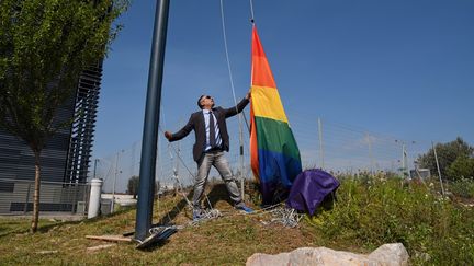 Le conseiller municipale Djamel Boumaaz démâte le drapeau LGBT hissé devant l'hôtel de ville à l'occasion de la journée internationale contre l'homophobie, le 18 mai 2016, à Montpellier (Hérault). (MAXPPP)