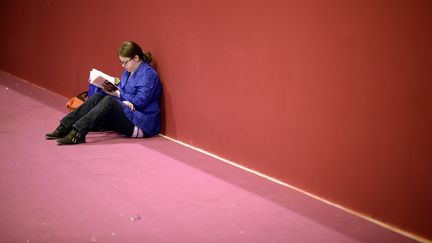 Une femme lit un livre au Salon du livre, le 21 mars 2014, &agrave; Paris. (MARTIN BUREAU / AFP)