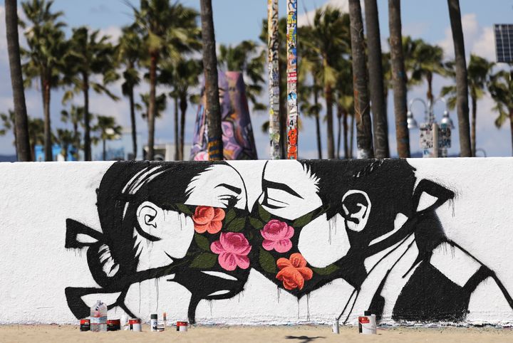 L'artiste Pony Wave a peint ces amoureux au temps du coronavirus sur un mur de Venice Beach, en Californie (Etats-Unis) avant le confinement décrété par le gouverneur de l'Etat Gavin Newsom pour faire face à la pandemie de Covid-19. (MARIO TAMA / GETTY IMAGES NORTH AMERICA)