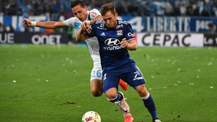 Maciej Rybus (en bleu) au duel avec le Marseillais Florian Thauvin.  (BORIS HORVAT / AFP)