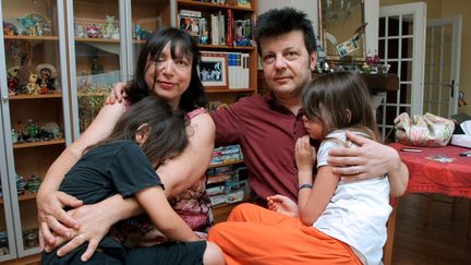 Sylvie et Dominique Mennesson, le 2 juillet 2009 à Maisons-Alfort (Val-de-Marne), avec leurs jumelles, nées d'une mère porteuse aux Etats-Unis. (PIERRE VERDY / AFP)