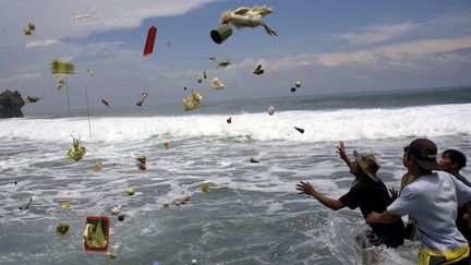 Des Indon&eacute;siens tentent d'attraper des offrandes jet&eacute;es &agrave; la mer par des Hindous lors d'une c&eacute;r&eacute;monie traditionnelle&nbsp;&agrave; Gunung Kidul (Indon&eacute;sie), le 7 mars 2012. (GEMBONG NUSANTARA / AP / SIPA)