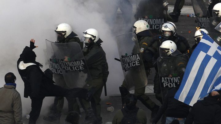 La police a fait usage de gaz lacrymog&egrave;ne dimanche 12 f&eacute;vrier pour repousser les manifestants&nbsp;devant le parlement &agrave; Ath&egrave;nes&nbsp;(Gr&egrave;ce). (YANNIS BEHRAKIS / REUTERS)