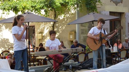 Ils ont surgi de nulle part, au milieu des cafés, sur une petite scène roulante véhiculée par un père attentionné. Deux filles et un garçon. Des reprises pop, deux voix fragiles et pas encore de nom. Mais déjà labellisés Yeah!. Ils sont ici chez eux et ça se sent : on a rarement vu aussi peu trace de trac en public chez des débutants.
 (Laure Narlian / Culturebox)