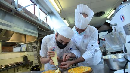 Un participant au concours du meilleur apprenti pâtissier de France prépare les finales avec son formateur, à Dunkerque (Nord). (MARC DEMEURE / MAXPPP)