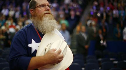 Le r&eacute;publicain porte le chapeau. Fi&egrave;rement. Pour pouvoir plus de prestance &agrave; l'&eacute;coute de l'hymne am&eacute;ricain. (ERIC THAYER / REUTERS)