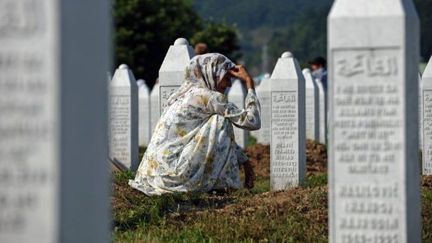 Une Bosniaque se recueille sur la tombe d'un proche dans le cimetière de Potocari, près de Srebrenica (11 juillet 2011). (ANDREJ ISAKOVIC / AFP)