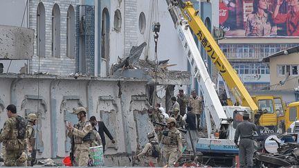 Les secours fouillant les décombres du batiments visé par&nbsp;les talibans, à Kaboul, le 19 avril 2016.&nbsp; (SHAH MARAI / AFP)