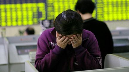 Une femme inqui&eacute;t&eacute;e par la chute des cours de la Bourse de Shangha&iuml; &agrave; Nantong, dans la province du Jiangsu (Chine), le 8 juillet 2015. (XU CONGJUN / IMAGINECHINA / AFP)