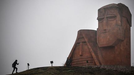 Un homme se dirige vers la statue "Nous sommes nos montagnes" de Sargis Baghdasaryan, symbole de l'héritage arménien de la région du Haut-Karabakh, à l'extérieur de la capitale de la province contestée, Stepanakert, le 12 novembre 2020. (ALEXANDER NEMENOV / AFP)