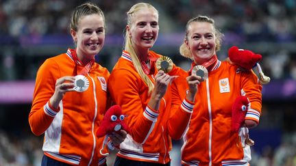 Les Néerlandaises Kimberly Alkemade, médaillée d'argent, Fleur Jong en or et Marlene van Gansewinkel en bronze sur le podium du 100 m T64, le 6 septembre 2024 au Stade de France, lors des Jeux paralympiques. (DIMITAR DILKOFF / AFP)