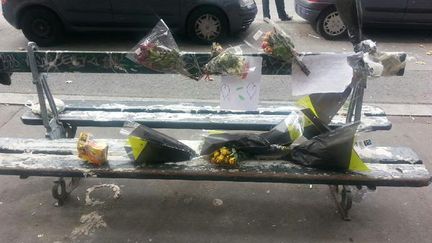 Les habitants du boulevard Vincent-Auriol, dans le 13e arrondissement de Paris, ont d&eacute;pos&eacute; des fleurs sur le banc o&ugrave; est mort un sans-abri, le 26 juillet 2015. (BABOUCAR DIAO / RAPHAEL GODET / TWITTER)