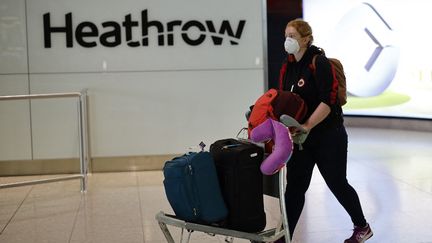 Une passagère portant un masque FFP2 lors de son arrivée au terminal 2 de l'aéroport international d'Heathrow à Londres (Angleterre), le 24 février 2021. (TOLGA AKMEN / AFP)