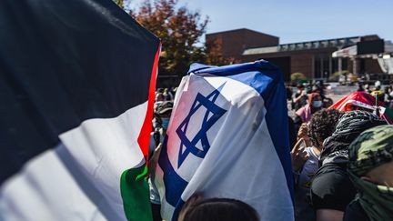 Un homme drapé d'un drapeau israélien traverse un rassemblement pro-palestinien à Seattle dans l'État de Washington aux États-Unis, le 12 octobre 2023. (CHIN HEI LEUNG / MAXPPP)