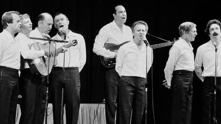 Gérard Sabbat (à gauche) et ses "Compagnons de la Chanson"... Au centre, avec un micro, on reconnaît Fred Mella (Paris, 24/8/1983).
 (Jacques Postel / AFP)