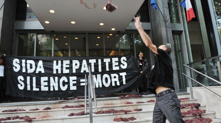 Des militants d'Act Up jettent des foies d'animaux devant le minist&egrave;re de la Sant&eacute;, le 19 mai 2010, pour protester contre la politique fran&ccedil;aise concernant le sida et les h&eacute;patites. (BERTRAND LANGLOIS / AFP)