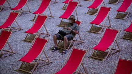 Un homme attend le début d'un spectacle dans la "Cour d'Honneur du Palais des Papes" à Avignon, le 18 juillet 2020. (CLEMENT MAHOUDEAU / AFP)